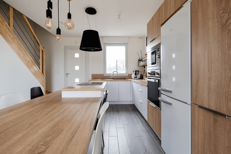 Cuisine ouverte bois et blanche avec îlot central à Héric | Raison Home